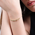 Close-up of a woman&#39;s wrist adorned with an 18K Gold Vermeil beaded bracelet featuring multiple small and large round beads arranged in a delicate pattern.