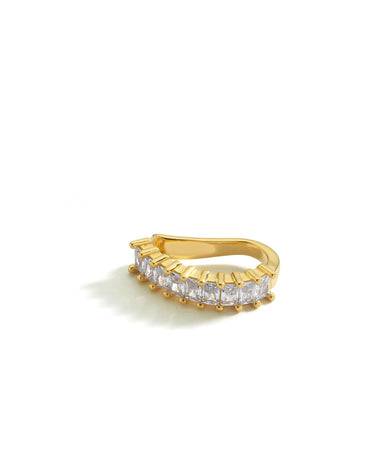 A gold ear cuff with baguette-cut clear stones, shown against a white background. The cuff is designed to fit snugly around the upper ear with a sleek, curved band.