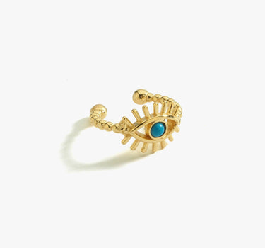 Gold vermeil ear cuff in the shape of an eye with a turquoise stone at the center, displayed on a white background.