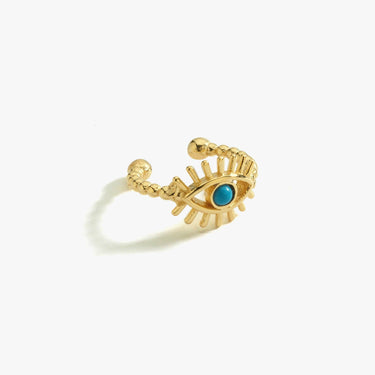 Gold vermeil ear cuff in the shape of an eye with a turquoise stone at the center, displayed on a white background.