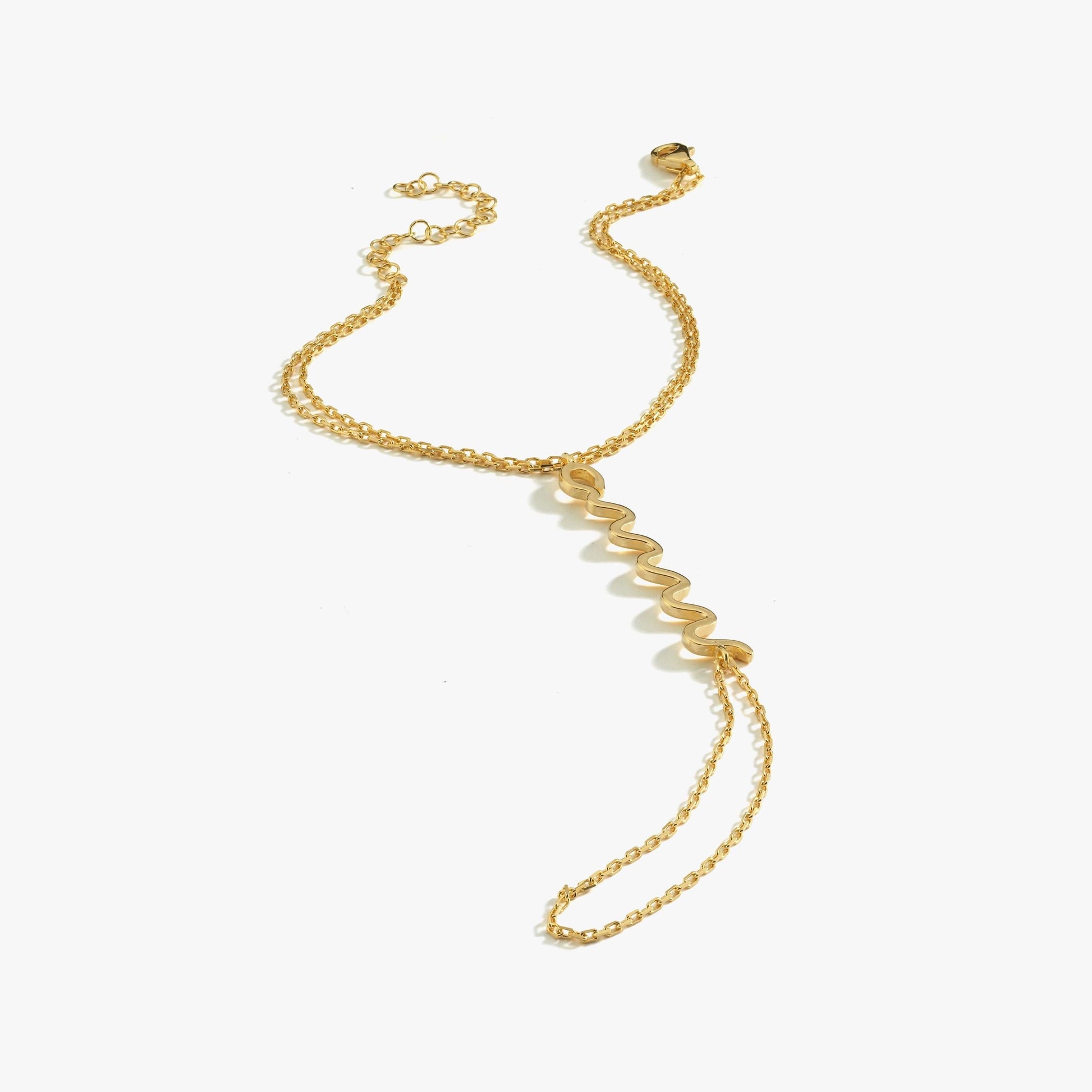 A single gold snake hand chain bracelet with a zigzag design, laid flat against a white background.