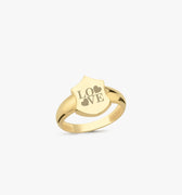 A 14K solid gold initial ring with a shield-shaped face engraved with the word &quot;LOVE&quot; and two heart symbols, displayed on a plain white background.