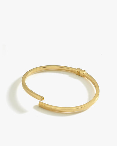 A product shot of the 18K gold vermeil hinged bangle bracelet, displaying its open-ended design on a white background.