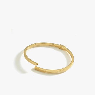 A product shot of the 18K gold vermeil hinged bangle bracelet, displaying its open-ended design on a white background.