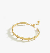 A product image of the 18K gold vermeil station cuff bracelet. The bracelet lies flat against a white background, displaying its curved design with small rounded stations and an adjustable chain closure.