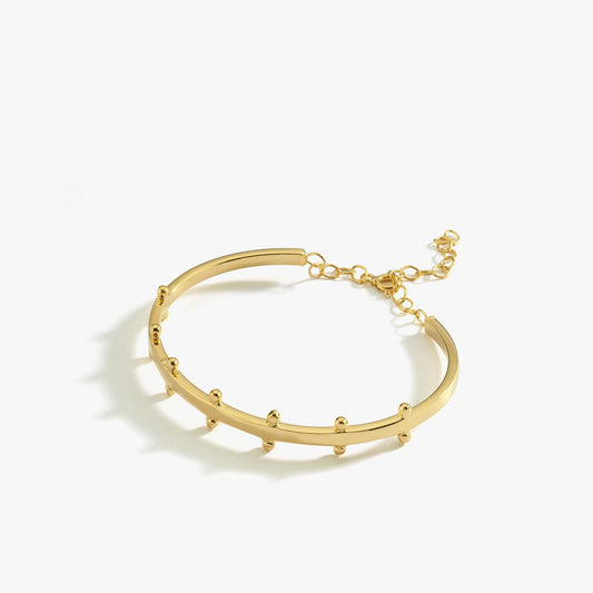 A product image of the 18K gold vermeil station cuff bracelet. The bracelet lies flat against a white background, displaying its curved design with small rounded stations and an adjustable chain closure.