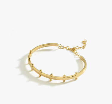 A product image of the 18K gold vermeil station cuff bracelet. The bracelet lies flat against a white background, displaying its curved design with small rounded stations and an adjustable chain closure.