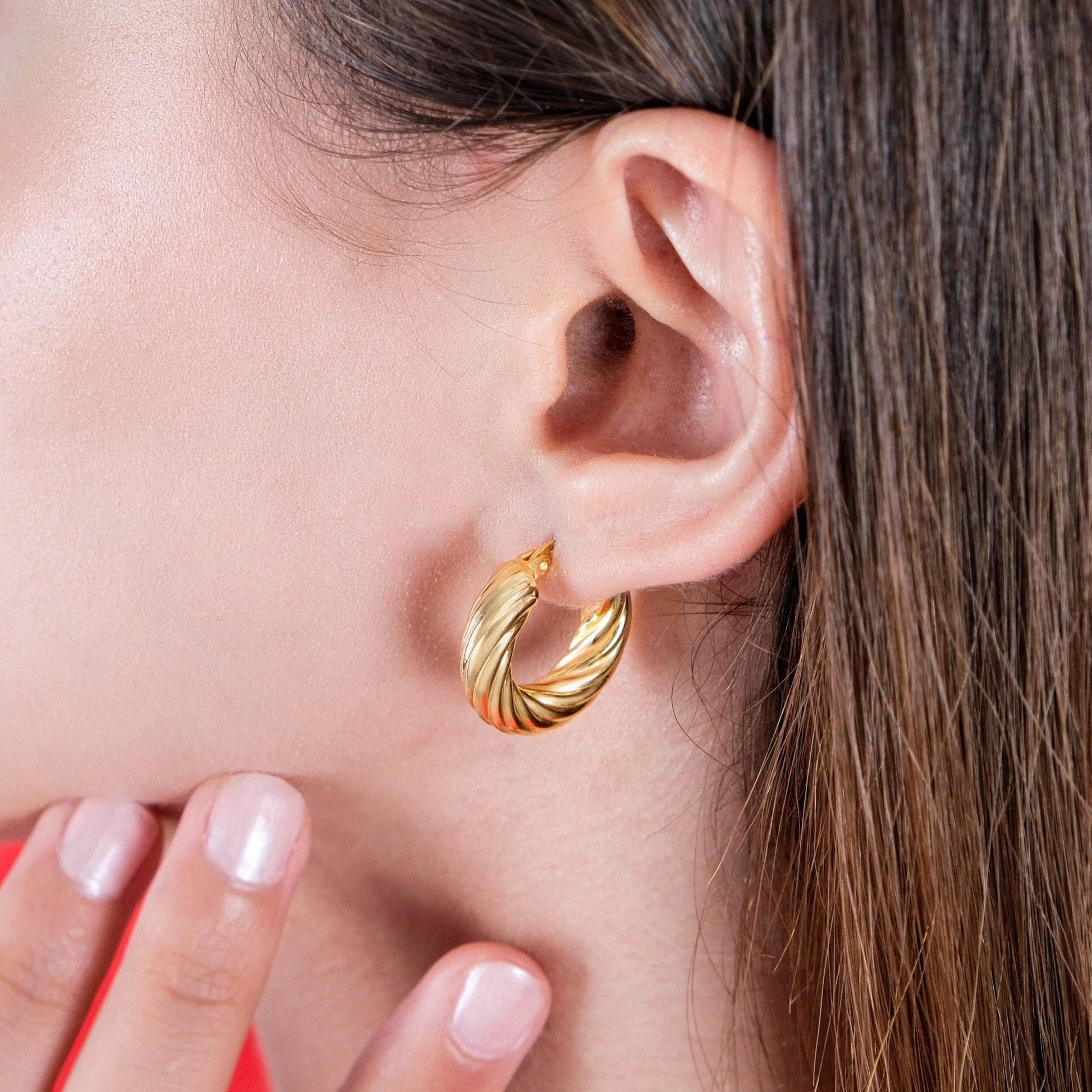 Close-up of an ear wearing an 18K gold vermeil chunky hoop earring.