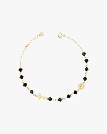 A 14K gold bracelet with black onyx beads, a cross charm, and a small medallion, displayed flat on a white background.