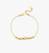 A high-angle view of the 18K Gold Vermeil beaded bracelet, highlighting its smooth, polished beads and secure clasp against a white background.