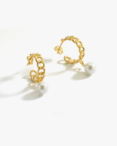 Pair of gold hoop earrings with pearl drops on a white background.