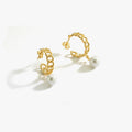 Pair of gold hoop earrings with pearl drops on a white background.