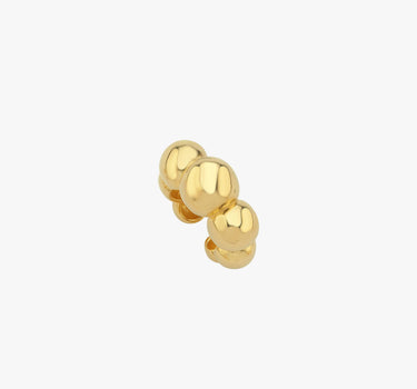 Close-up view of a gold ear cuff with three spherical beads on a white background.