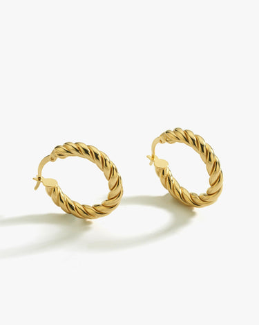 A pair of medium-sized twisted hoop earrings in 18K gold vermeil on a white background.