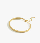 A single thin gold vermeil bangle bracelet with a delicate chain clasp, displayed on a white background.