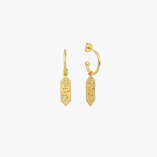 A pair of 18k gold vermeil dangle earrings with a rectangular charm featuring a snake design, set against a plain white background.