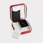 The interior of a red jewelry box, showcasing a neatly placed First Holy Communion Bracelet along with a certificate.