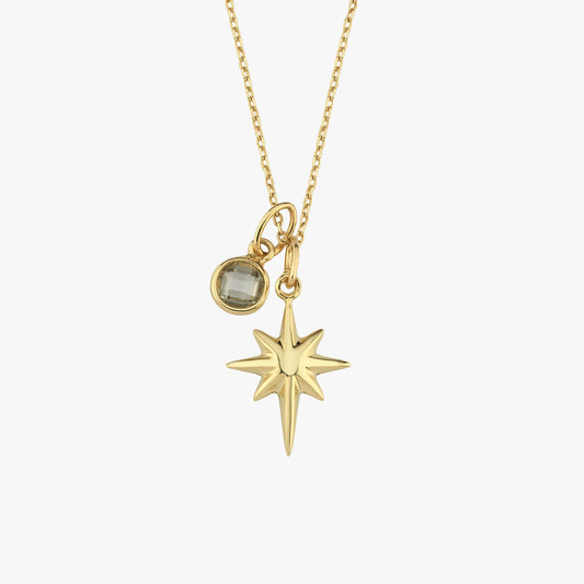 The 14K Solid Gold North Star Pendant features a radiant star charm alongside a small gemstone, creating an elegant celestial look.