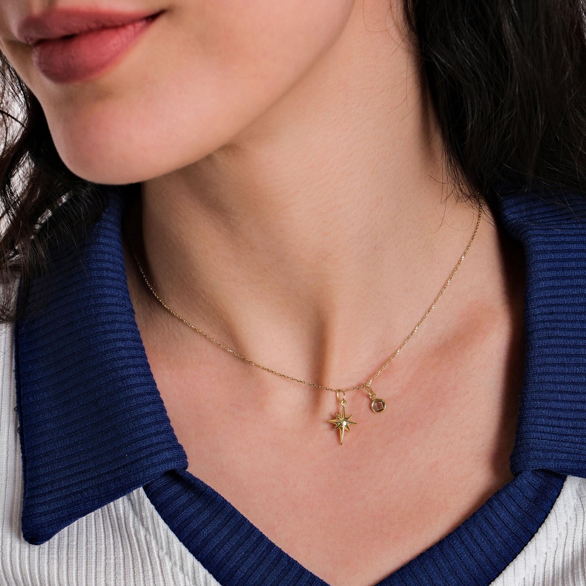 A side angle of the 14K Solid Gold North Star Pendant, emphasizing its delicate star shape and brilliant shine.