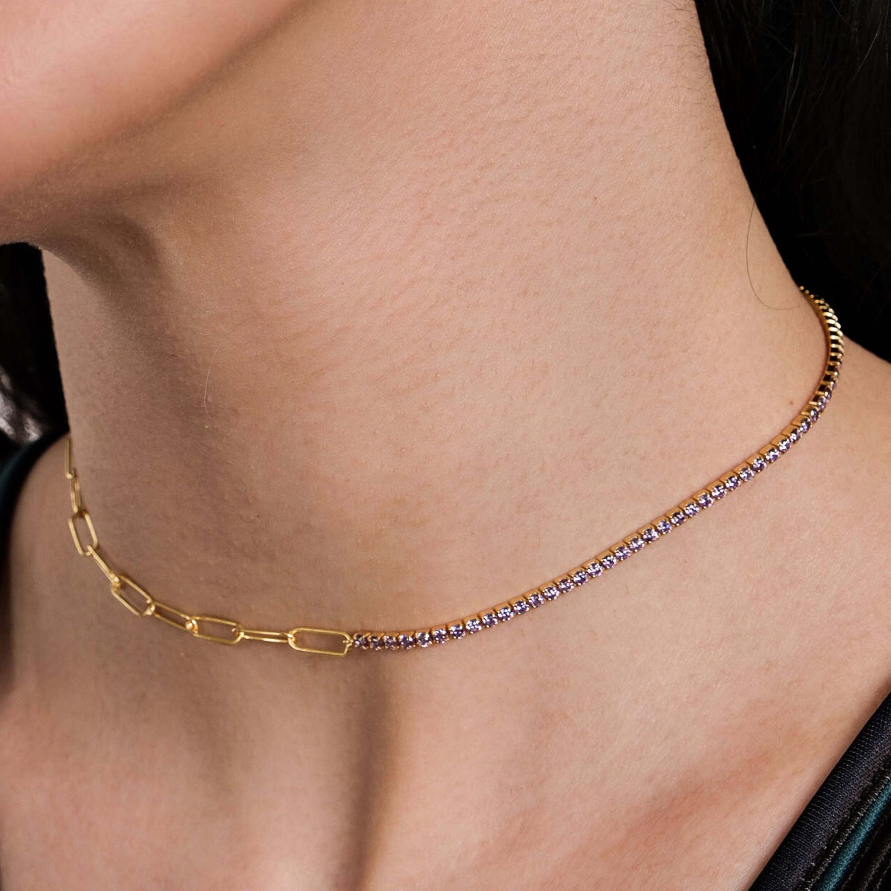 A woman's neck adorned with an 18K Gold Vermeil Paperclip & Tennis Necklace, featuring gold links and sparkling stones.