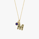 A close-up product shot of the 14K Solid Gold Initial Necklace with Birthstone, showcasing the intricate engraving on the letter charm and the rich hue of the sapphire birthstone.