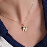 A delicate 14K Solid Gold Initial Necklace with Birthstone, featuring a textured gold letter charm and a deep blue birthstone, elegantly displayed on a woman's collarbone.