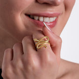 A bold 18K gold vermeil snake ring with a fluid, sculptural design wrapping around the finger.