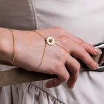 The bracelet wraps around the wrist and finger, creating a unique and graceful jewelry piece.