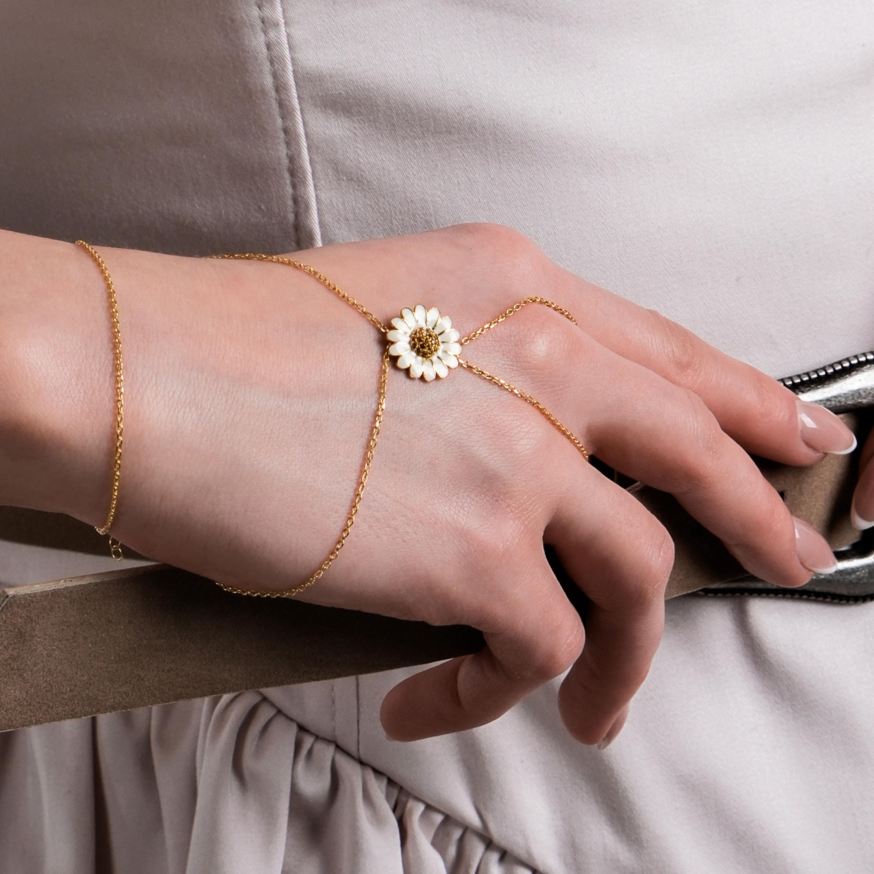 The bracelet wraps around the wrist and finger, creating a unique and graceful jewelry piece.