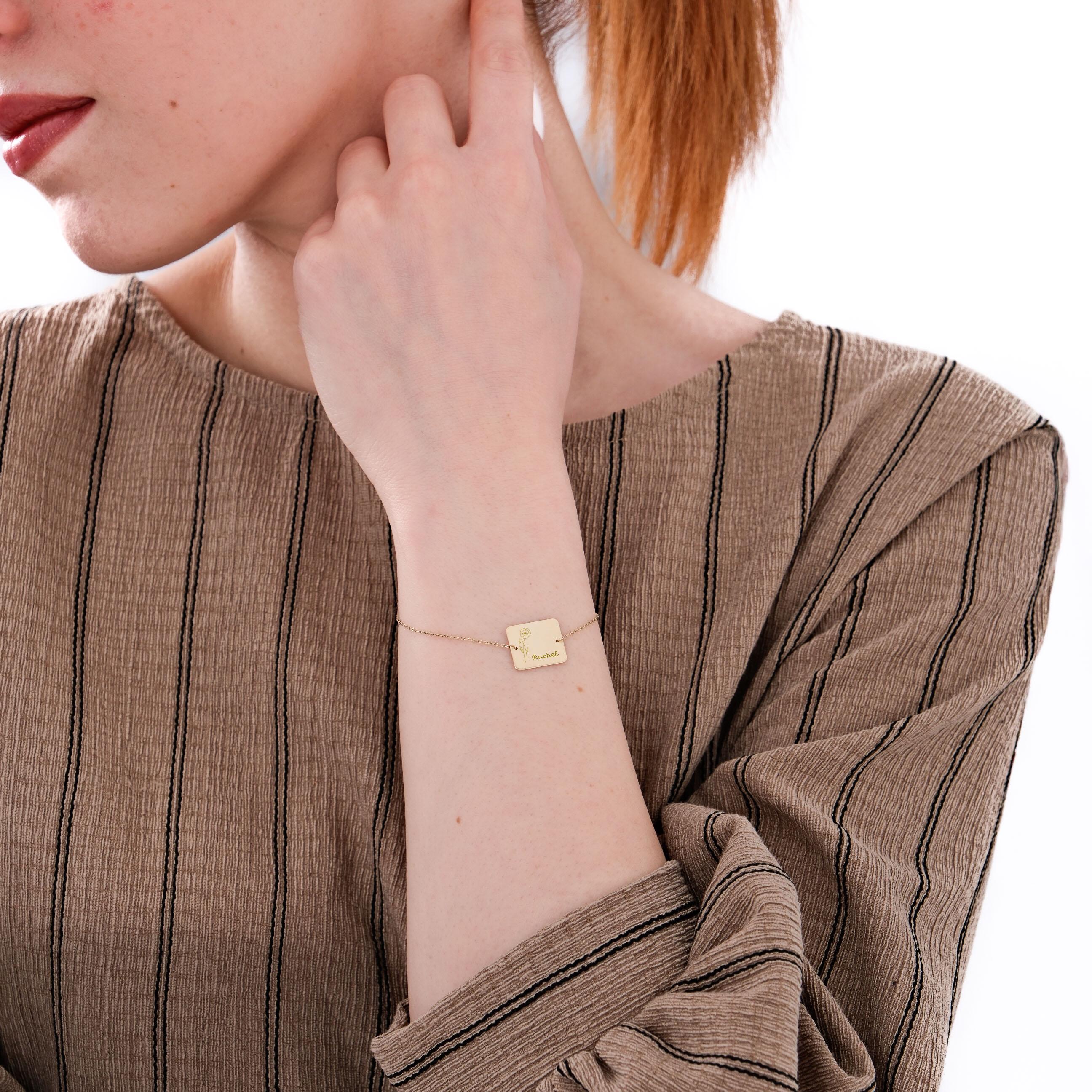 Side view of a woman wearing a 14K solid gold birthflower bracelet with a floral engraving and “Rachel” inscription.