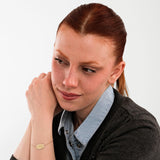 Top view of a 14K solid gold bracelet featuring an oval plate engraved with the initials “SHB” and an adjustable chain clasp.