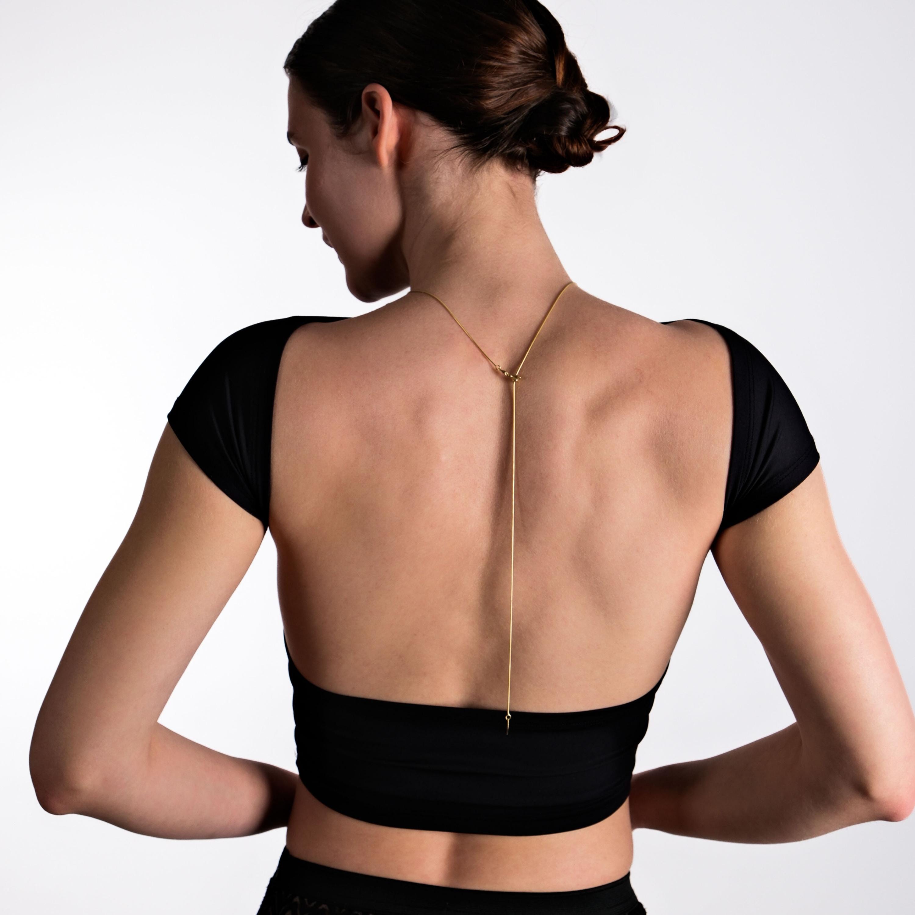 A model wears a delicate 18K Gold Vermeil Long Back Necklace, draping elegantly down her back, complementing her open-back black top.