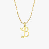 A 14K solid gold cursive initial necklace with a "B" charm is displayed against a plain, neutral background.