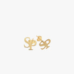 Detailed shot of 14K solid gold intertwined initial earrings with butterfly backings, displaying the “S” and “P” monogram design.
