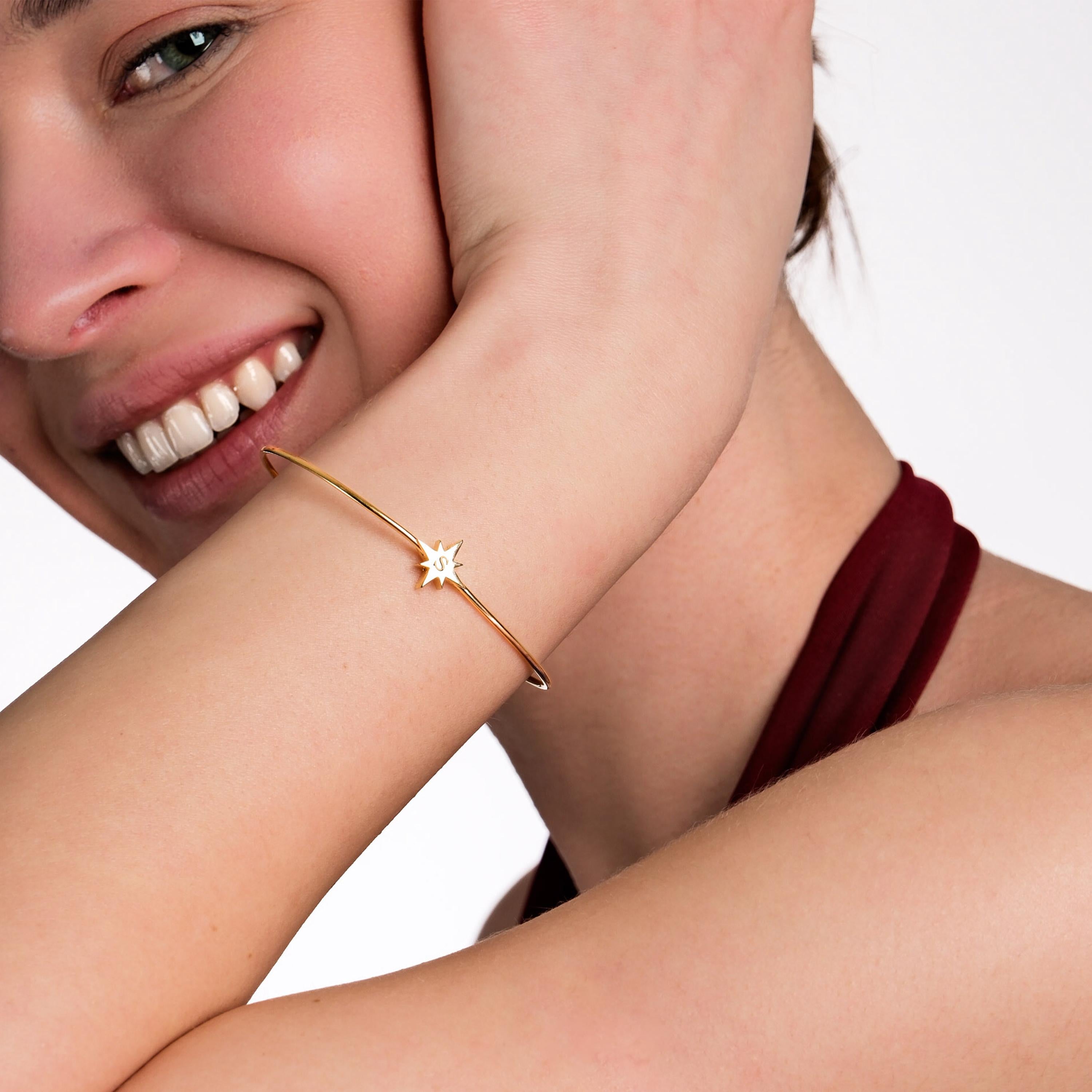 A stylish 18K Gold Vermeil Initial Cuff Bracelet elegantly wraps around the wrist, adding a touch of personalization.