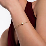 A delicate 18K Gold Vermeil Initial Cuff Bracelet featuring a personalized star charm on a sleek, minimalist bangle.