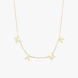 Detailed close-up of the "MAMA" letter charms on a 14K solid gold necklace, photographed against fair skin.