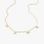 Isolated product shot of a 14K solid gold mama necklace on a white background, showing the fine chain and bold letter charms.