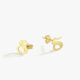 A pair of 14K Solid Gold Initial Stud Earrings displayed on a white background, featuring a sleek, calligraphic “S” design.