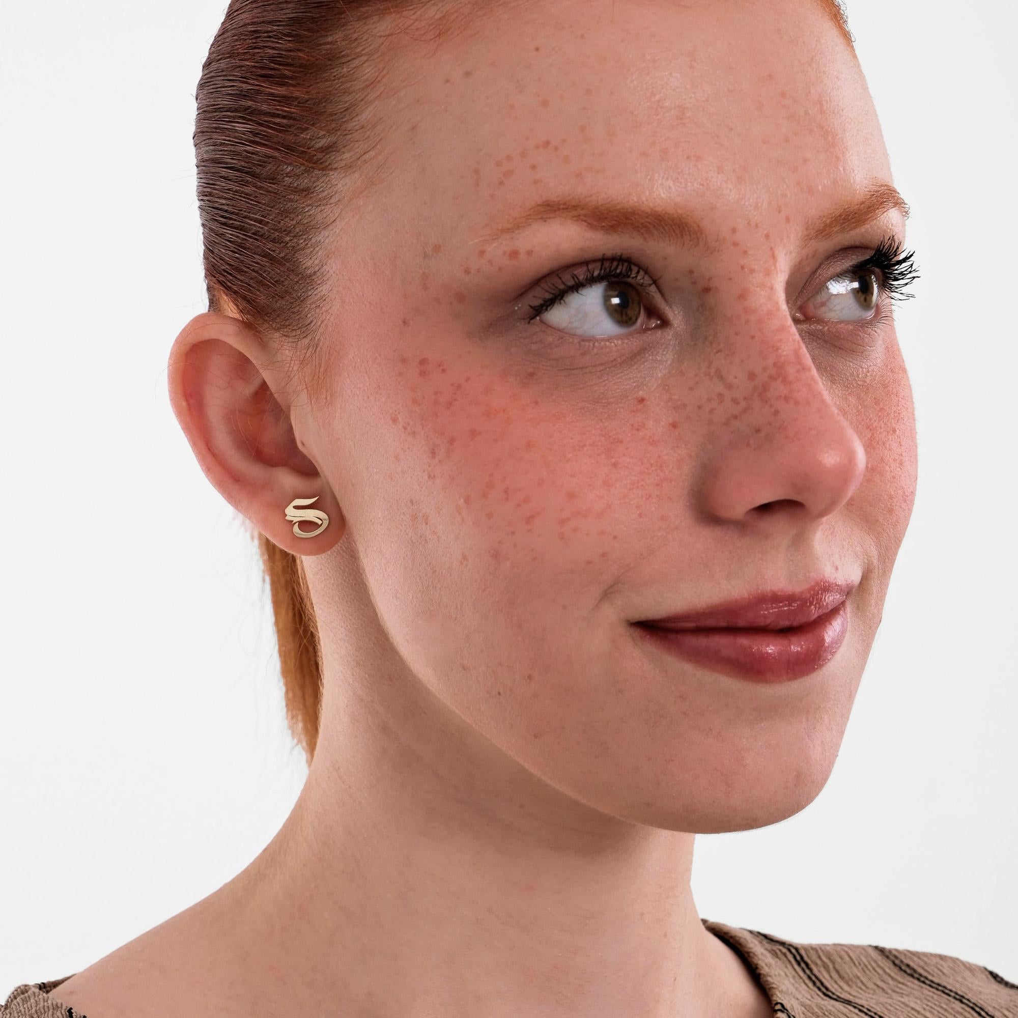 The model looks upward with a soft smile, wearing a 14K Solid Gold Initial Stud Earring that adds a subtle personal touch.