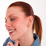 Model wearing 18K gold vermeil birthstone earrings with sapphire centers, styled for a joyful and elegant look.