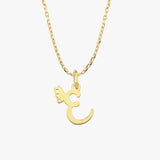 Delicate 14K solid gold custom letter necklace with butterfly charm laid flat on a white surface, highlighting the "E" initial pendant.