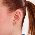 18K gold vermeil birthstone earrings with sapphire accents, worn on the ear to highlight their golden detail.