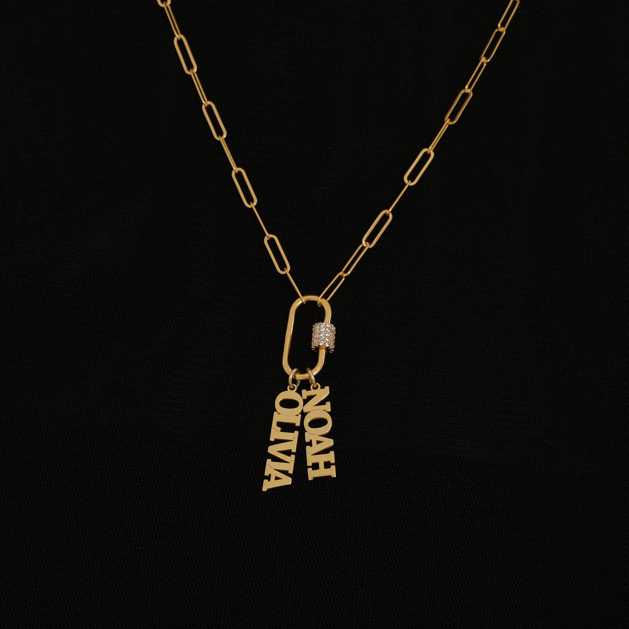 18K gold vermeil carabiner charm necklace featuring two bold name pendants, “NOAH” and “OLIVIA,” on a textured paperclip chain, shown against a white background.