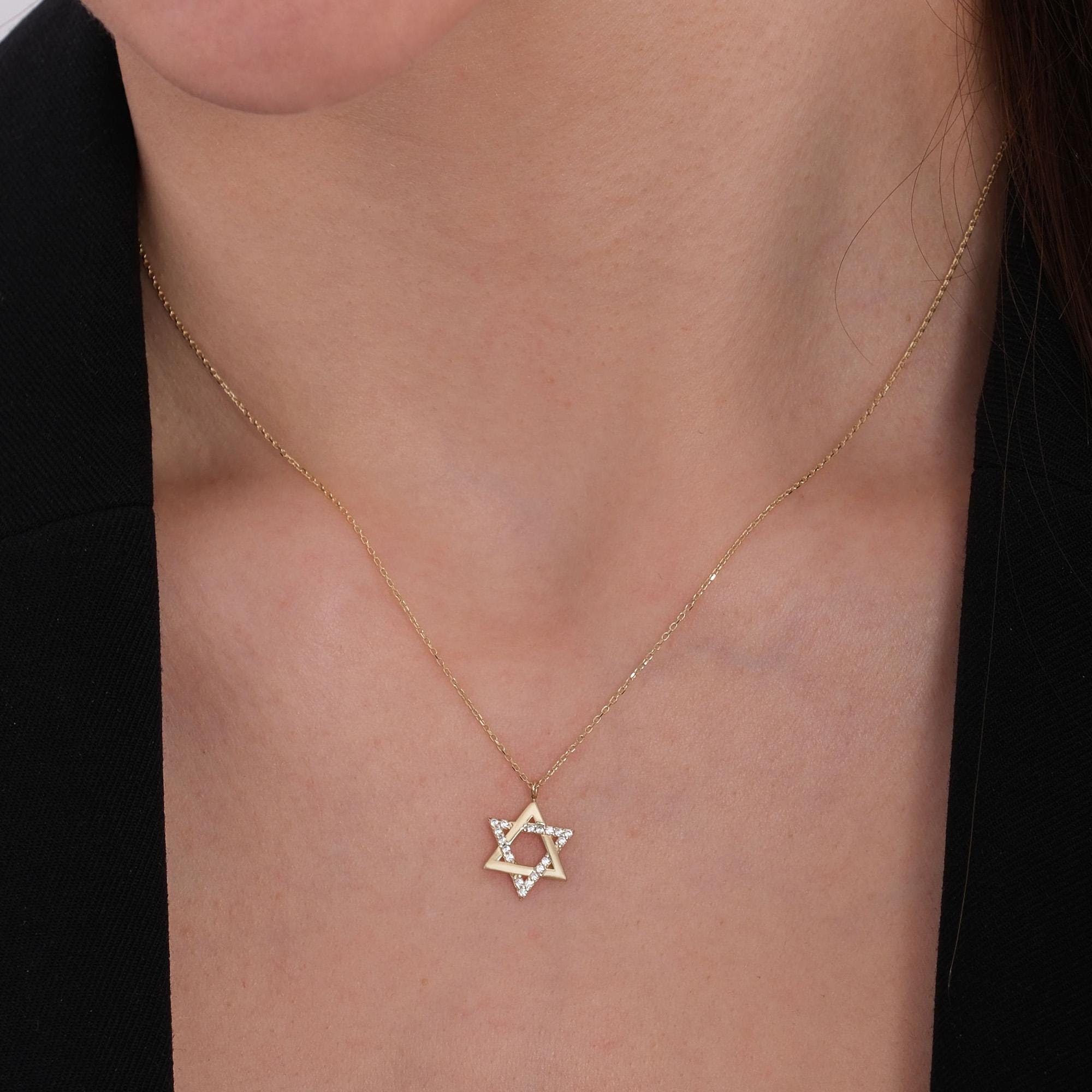 Close-up of a woman’s neck wearing a 14K solid gold Star of David necklace with tiny diamonds on a fine gold chain.