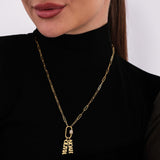 Close-up side view of a woman wearing a personalized 18K gold vermeil necklace with carabiner clasp and name charms, layered on a minimal black outfit.
