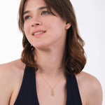 The minimalist charm of the 14K Solid Gold Pineapple Fruit Necklace is emphasized in a flat lay with tropical elements.