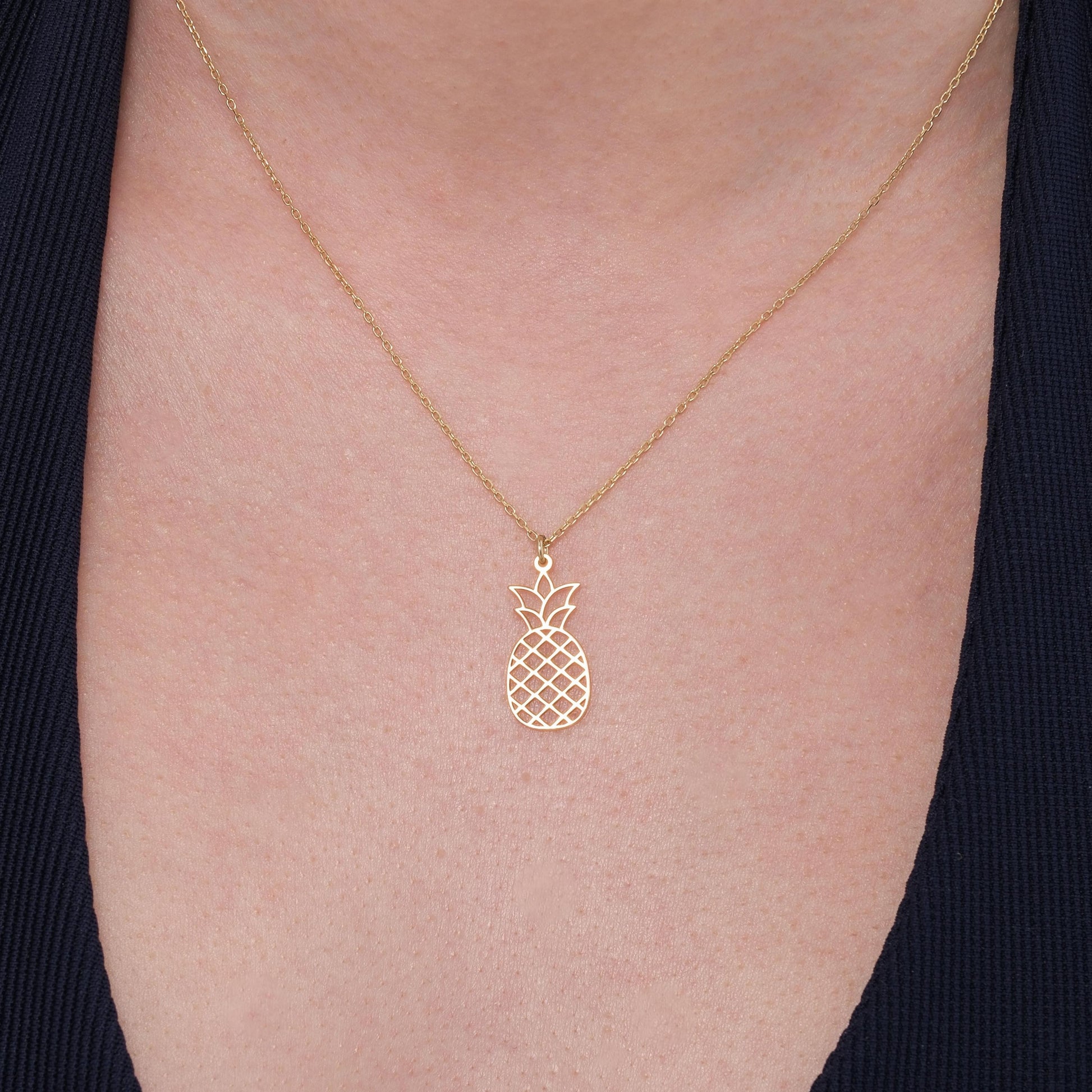 A model wears a 14K Solid Gold Pineapple Fruit Necklace close to the collarbone, showcasing the pendant&#39;s delicate shine.