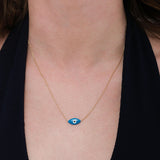 A woman’s neck styled with a 14K solid gold evil eye necklace featuring a sleek blue enamel charm.