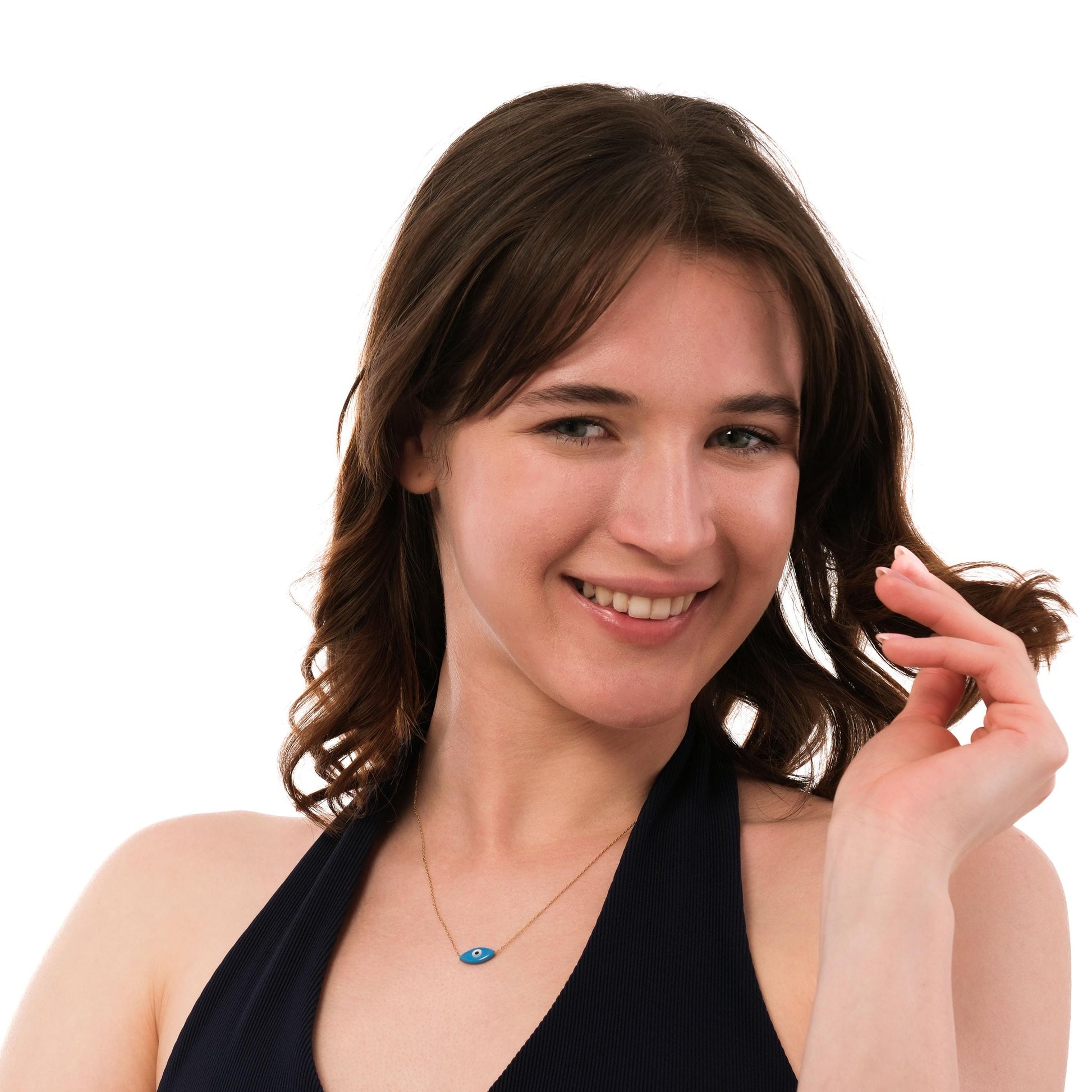 Portrait of a model wearing the 14K solid gold evil eye necklace, pairing its bold blue charm with an elegant smile.